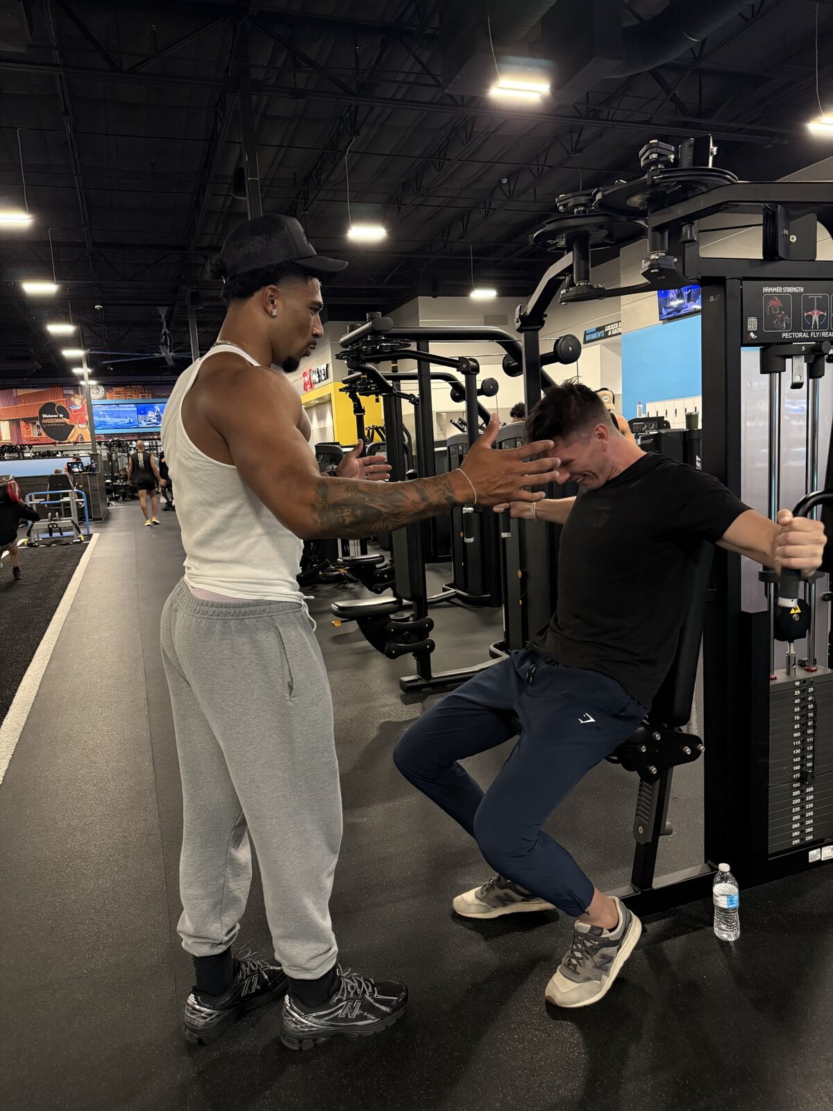 Coach Brendan training a client on a chest fly machine